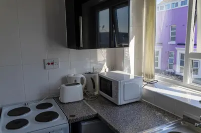 a kitchen with a microwave and a stove and a window at One Bedroom Flat by Brookland Stays Serviced Accommodation Short Lets Blackpool with Free WiFi in Blackpool
