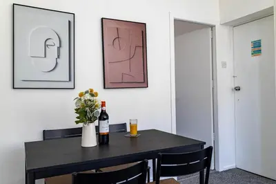 a dining room table with a bottle of wine and flowers at One Bedroom Flat by Brookland Stays Serviced Accommodation Short Lets Blackpool with Free WiFi in Blackpool