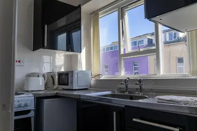 a kitchen with a sink and a microwave at Brookland Stays Blackpool 1BR Apartment Sleeps 4 WiFi in Blackpool