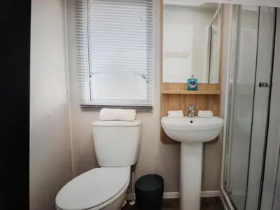 a small bathroom with a toilet and a sink at Poppy Lodge LE 17 Ocean's Edge Park in Morecambe