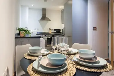 a dining room table with plates and bowls and wine glasses at Premium 10-Room Contractor Accommodation Central Location in Liverpool