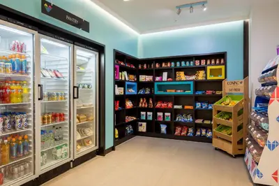 a store aisle with refrigerators and shelves of food at The Ascent in Liverpool