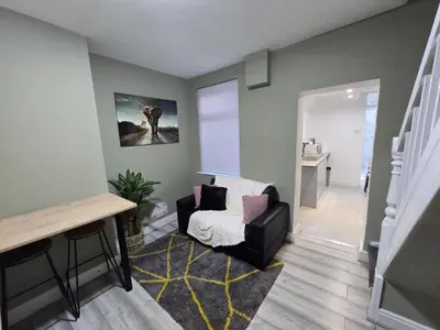 a living room with a chair and a stair case at House 5 Minutes from Sefton Park in Liverpool