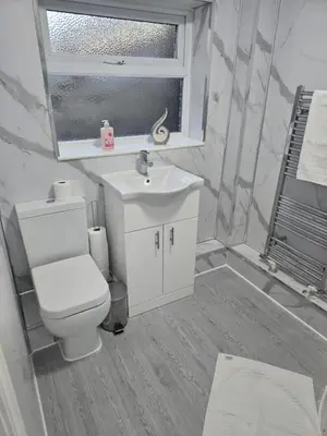 a bathroom with a toilet and a sink and a window at House 5 Minutes from Sefton Park in Liverpool