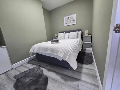a bedroom with a bed with a white comforter at Room 1 Shared house 5 min from Sefton Park in Liverpool