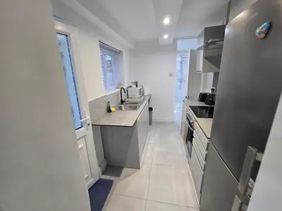 a white kitchen with a sink and a counter at Room 1 Shared house 5 min from Sefton Park in Liverpool
