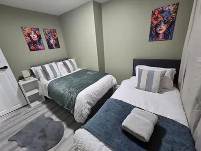 a small bedroom with two beds and paintings on the wall at Room 2 Shared house 5 min from Sefton Park in Liverpool