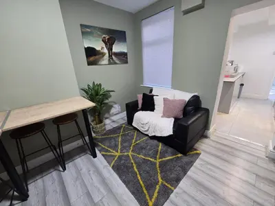 a living room with a chair and a table at Room 2 Shared house 5 min from Sefton Park in Liverpool