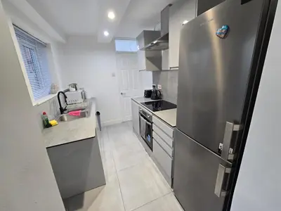 a kitchen with a stainless steel refrigerator and a sink at Room 3 Shared house 5 min from Sefton Park in Liverpool