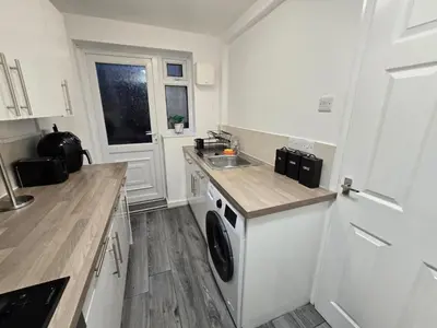 a kitchen with a washing machine and a sink at Room 1 Shared House 3 min from Stadium in Liverpool