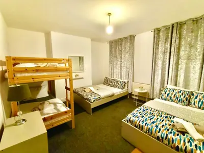 a bedroom with two beds and a bunk bed at Cosy 4 Bedroom Liverpool Contractor & Family Stay in Liverpool