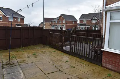 a backyard with a fence and some houses at Liverpool Redwood house in Liverpool
