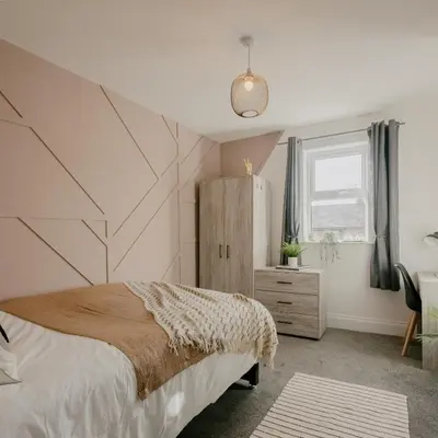 a bedroom with a bed with a geometric wall at Cosy New Brighton Room for Rent in New Brighton