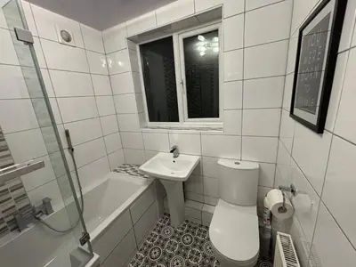 a white bathroom with a toilet and a sink at Entire House, Parking, Facilities, sleeps up to 6, suitable for contractors, families or NHS in Liverpool