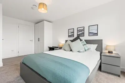 a bedroom with a large bed with a blue blanket at Business Stays, Modern Liverpool Flat, sleeps 4 in Liverpool