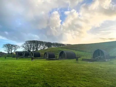 a group of three domes in a field with a hill at Birds - Uk48489 in Dalton in Furness