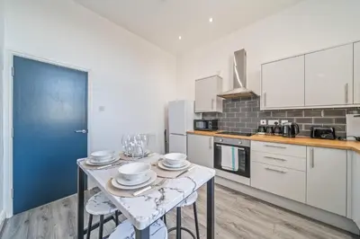 a kitchen with a table with dishes on it at Latimer Flat 3 - Spacious 2-Bed Apt - Sleeps 6 in Liverpool