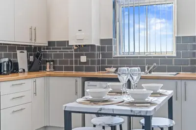 a kitchen with a table with wine glasses on it at Latimer Flat 6 - Spacious 2-Bed Apt - Sleeps 7 in Liverpool