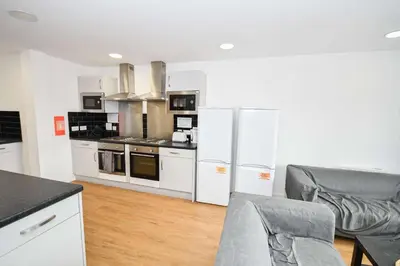 a kitchen with white appliances and a table and chairs at Modern & Convenient 4 Bed Apartment in Liverpool in Liverpool