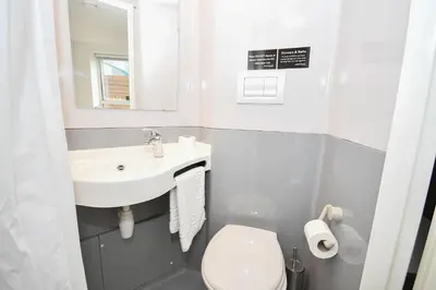 a small bathroom with a sink and a toilet at Modern & Convenient 4 Bed Apartment in Liverpool in Liverpool