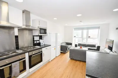 a kitchen and living room with a couch at Modern & Convenient 4 Bed Apartment in Liverpool in Liverpool