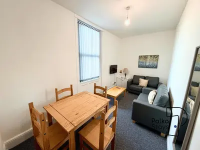 a living room with a table and a couch at Comfy Ormskirk Family Stay by PolkaStays in Ormskirk