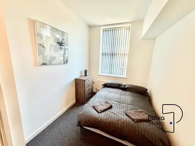 a bedroom with a bed and a window at Spacious Ormskirk Contractor Stay by PolkaStays in Ormskirk