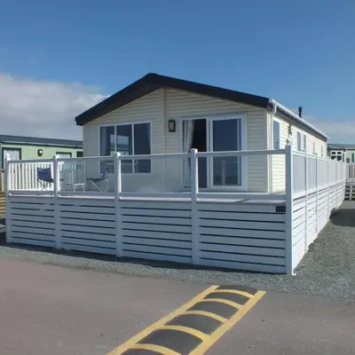 a small white house with a white fence at Shrimp Shack in Heysham