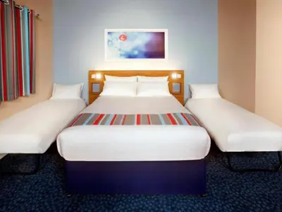 two beds in a hotel room with white beds at Travelodge Liverpool Stonedale Park in Liverpool