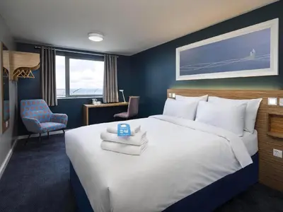 a bedroom with a large bed with towels on it at Travelodge Morecambe in Morecambe