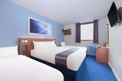 a hotel room with two beds and a tv at Travelodge Blackpool South Shore in Blackpool