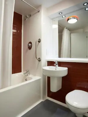 a bathroom with a sink and a toilet and a mirror at Travelodge Blackpool South Shore in Blackpool