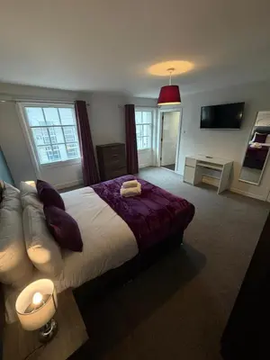 a bedroom with a large bed and a couch at City Centre 4 Bedroom Apartment with Terrace Sleeps 10 by StaySavvy Accommodation in Liverpool