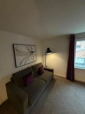 a living room with a couch and a window at City Centre 4 Bedroom Apartment with Terrace Sleeps 10 by StaySavvy Accommodation in Liverpool