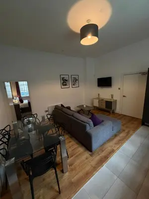 a living room with a couch and a table at Spacious 4 Bedroom Apartment with Terrace Liverpool by StaySavvy Accommodation in Liverpool