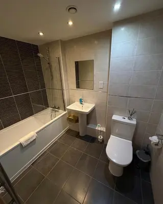 a bathroom with a toilet and a sink and a tub at 2-Bed City View with Balcony Liverpool by StaySavvy Accommodation in Liverpool