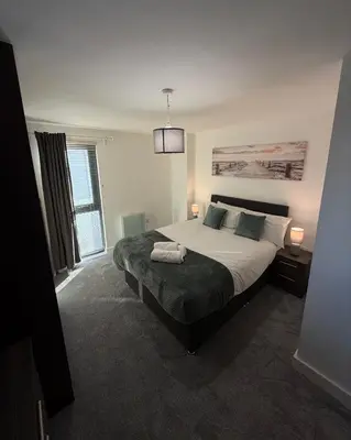 a bedroom with a large bed and a window at 2-Bed City View with Balcony Liverpool by StaySavvy Accommodation in Liverpool