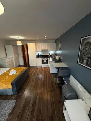 a large room with a bed and a kitchen at City View Studio Apartment Liverpool by StaySavvy Accommodation in Liverpool