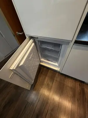 an open refrigerator in a kitchen with a wooden floor at City View Studio Apartment Liverpool by StaySavvy Accommodation in Liverpool