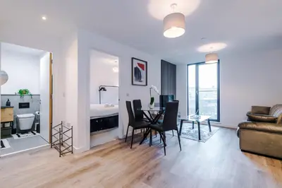 a living room with a table and chairs and a bedroom at Modern Central Preston Apt King Bed & Smart TV in Preston