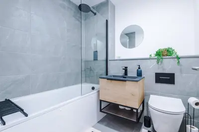 a bathroom with a sink and a toilet and a tub at Modern Central Preston Apt King Bed & Smart TV in Preston