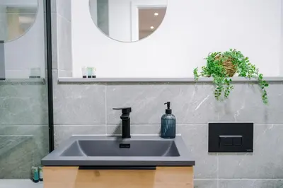 a bathroom sink with a soap bottle on it at Modern Central Preston Apt King Bed & Smart TV in Preston