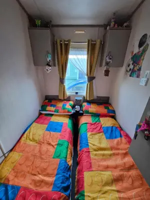 two beds in a small room with a window at 3 bed family caravan r12 in Heysham
