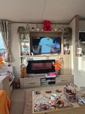 a living room with a flat screen tv in a entertainment center at 3 bed family caravan r12 in Heysham