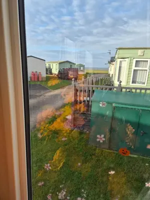 a view from a window of a yard with a fence at 3 bed family caravan r12 in Heysham