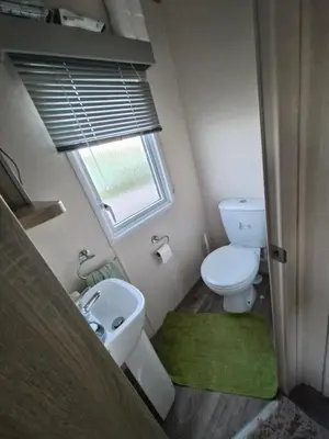 a small bathroom with a toilet and a sink at Hill family residence in Morecambe
