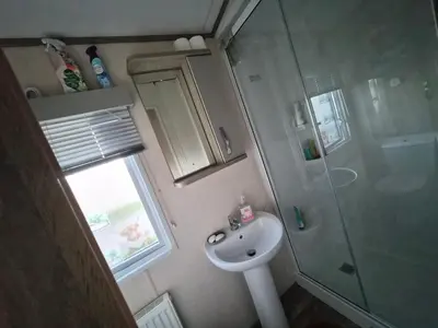 a small bathroom with a sink and a shower at Hills residence in Morecambe