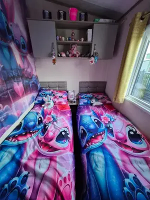 a bedroom with two beds and a child in a room at Hills residence in Heysham