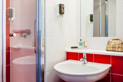 a white bathroom with a sink and a shower at Forshaws Hotel - Blackpool in Blackpool