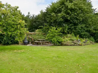 a picnic table in a yard with trees and grass at The Stable in Burscough
